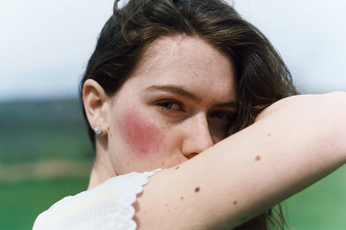 Woman with freckles and blush outdoors