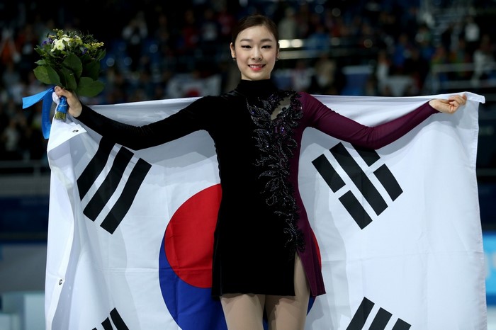 Kim Yuna holding South Korean flag and flowers