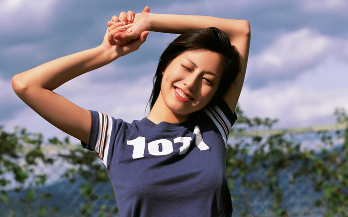 Yumi Sugimoto smiling with arms raised