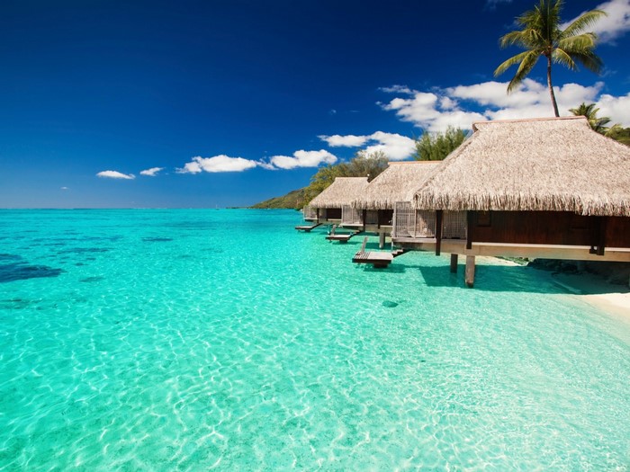 Overwater bungalows in a tropical turquoise lagoon