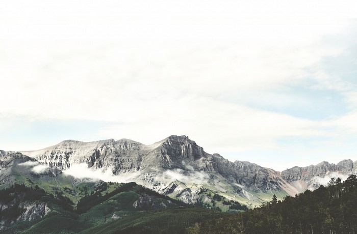 Mountain range with clouds and trees