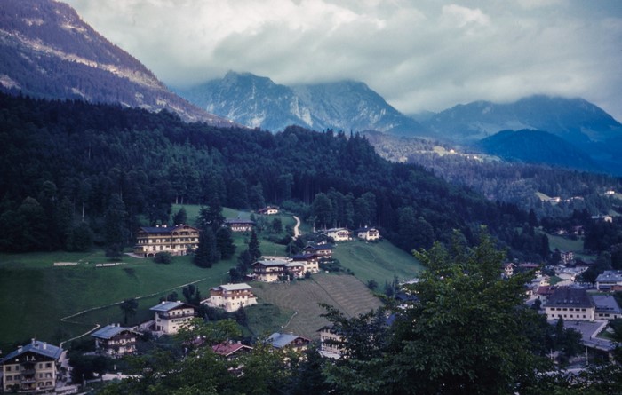 Village nestled in a mountain valley with dense forests