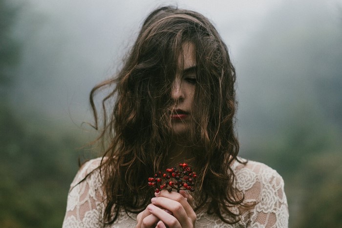 Woman with berries and hair in face