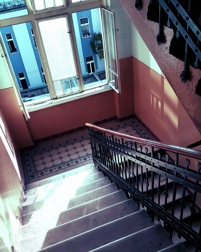 Staircase with window overlooking blue building