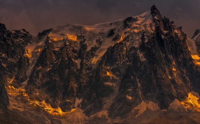 Jagged mountain peaks illuminated by golden sunlight