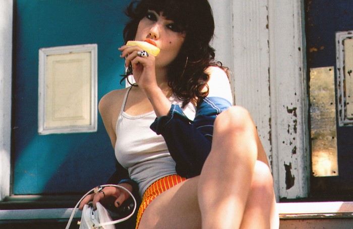 Woman eating a popsicle while sitting outdoors