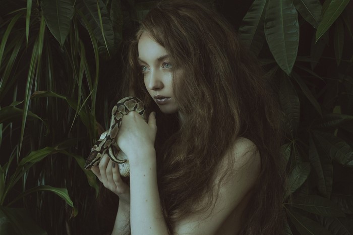 Woman with snake in jungle
