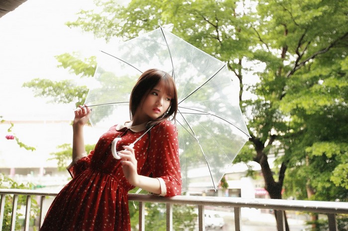 Asian woman in red dress holding umbrella