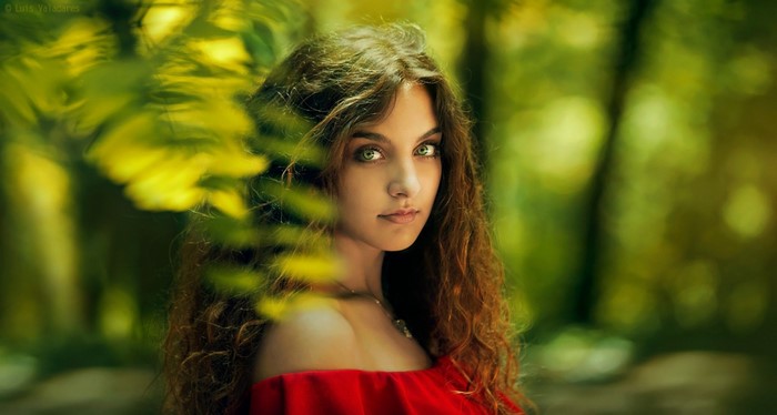 Woman with Green Eyes in Sunlit Forest