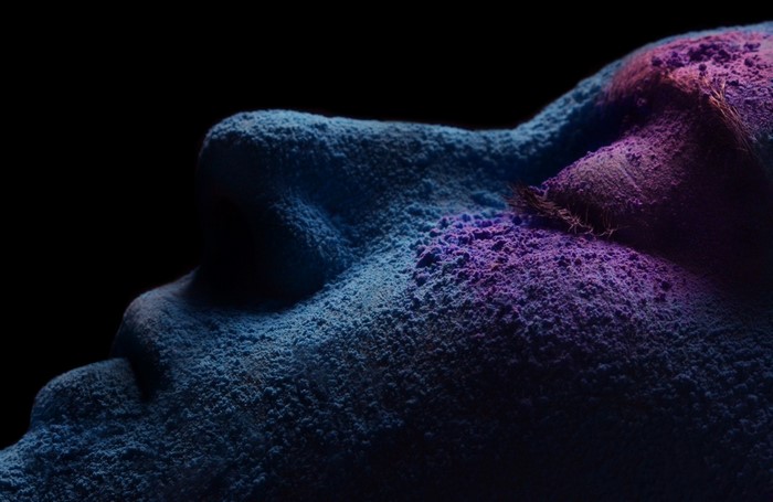 Close-up of face covered in blue and purple pigments