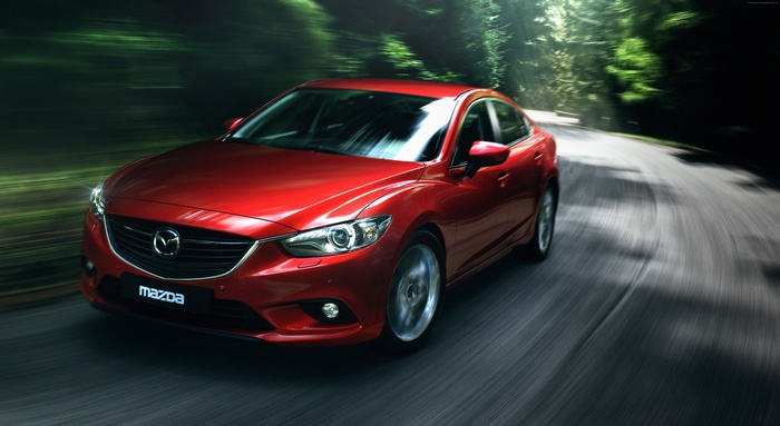 Red Mazda 6 driving on a winding road