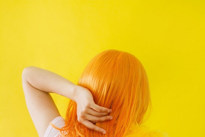 Woman with orange hair on yellow background