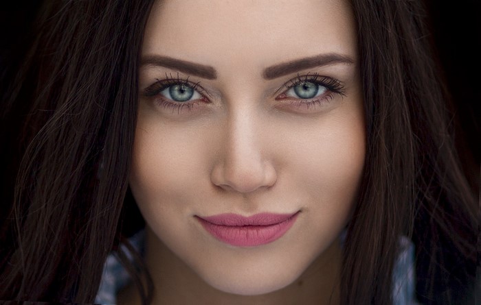 Close-up portrait of a woman with blue eyes and pink lips