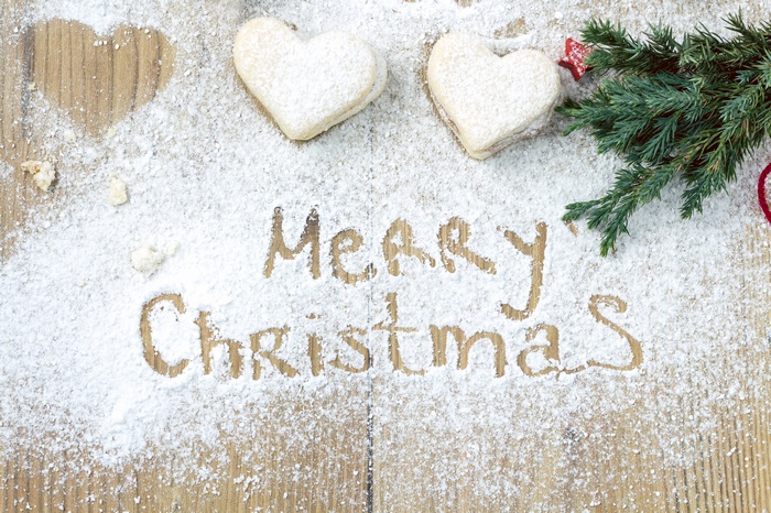 Merry Christmas cookies and pine branch on wood