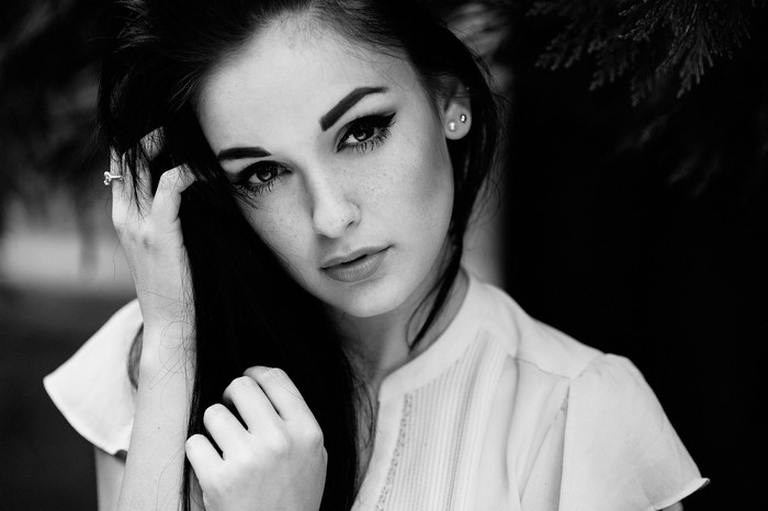 Monochrome portrait of a woman with hands in her hair