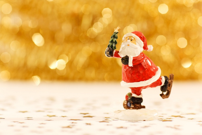 Santa Claus figurine ice skating with Christmas tree