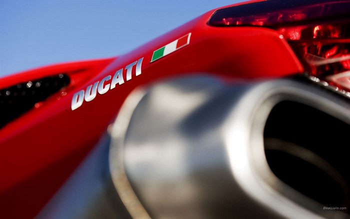 Close-up of a red Ducati motorcycle exhaust and logo
