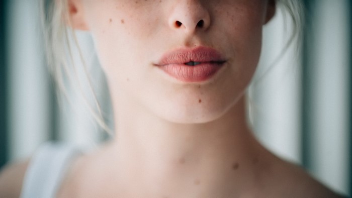 Close up of a woman's face with freckles and lips