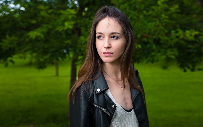 Woman in leather jacket in park