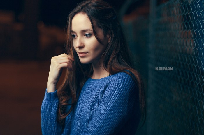 Woman in blue sweater by fence