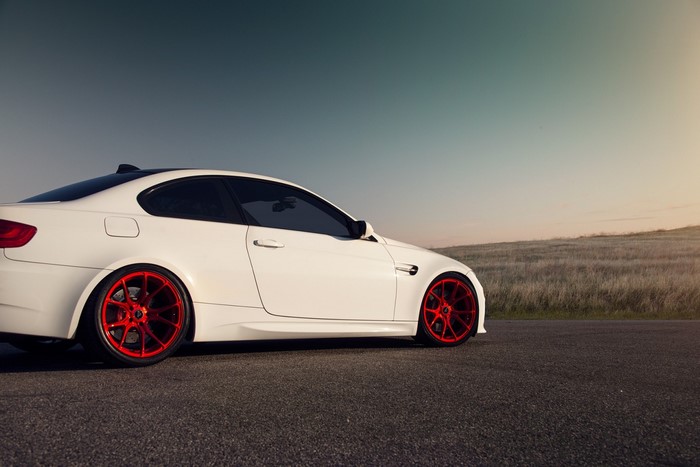 White BMW M3 Coupe with Red Rims on Road