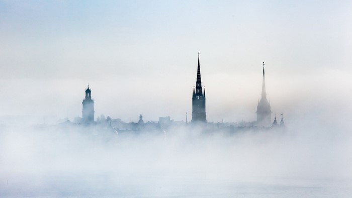 City skyline shrouded in fog with church spires