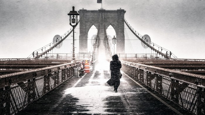 Person walking on Brooklyn Bridge in snow