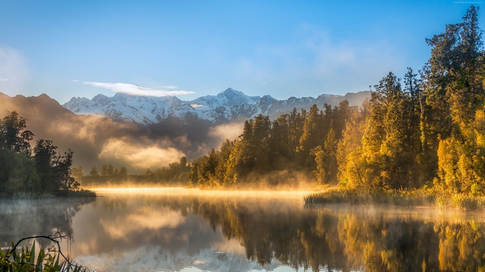 Misty Lake with Snow-Capped Mountains and Autumn Forest