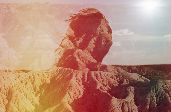 Double exposure of a woman's face over a desert landscape