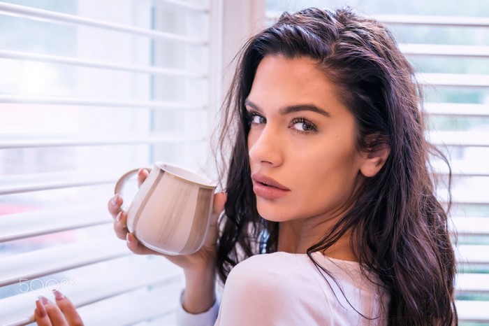 Woman holding a mug by the window
