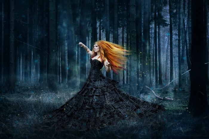 Fantasy woman in black dress in dark forest