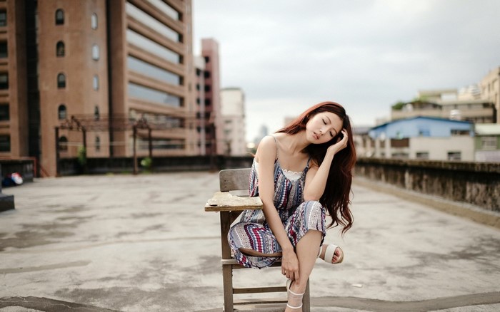 Woman with long hair sitting on a chair outdoors