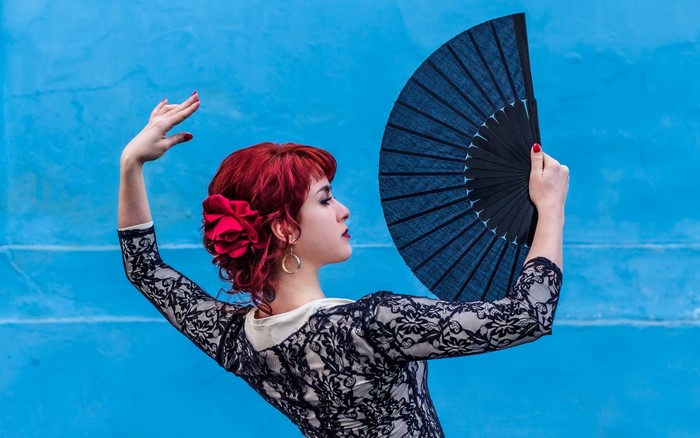 Woman with red hair holding a fan