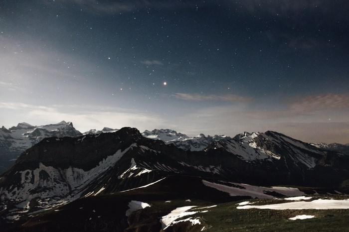 Snow-capped mountains under a starry night sky