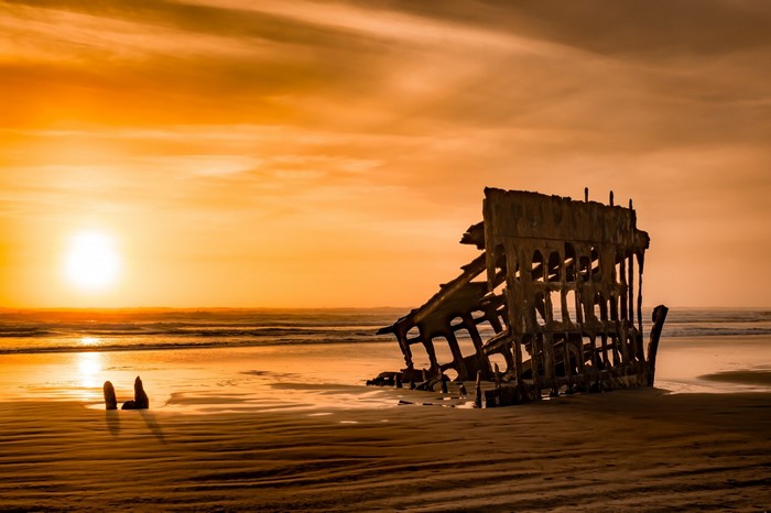 Shipwreck on a beach at sunset