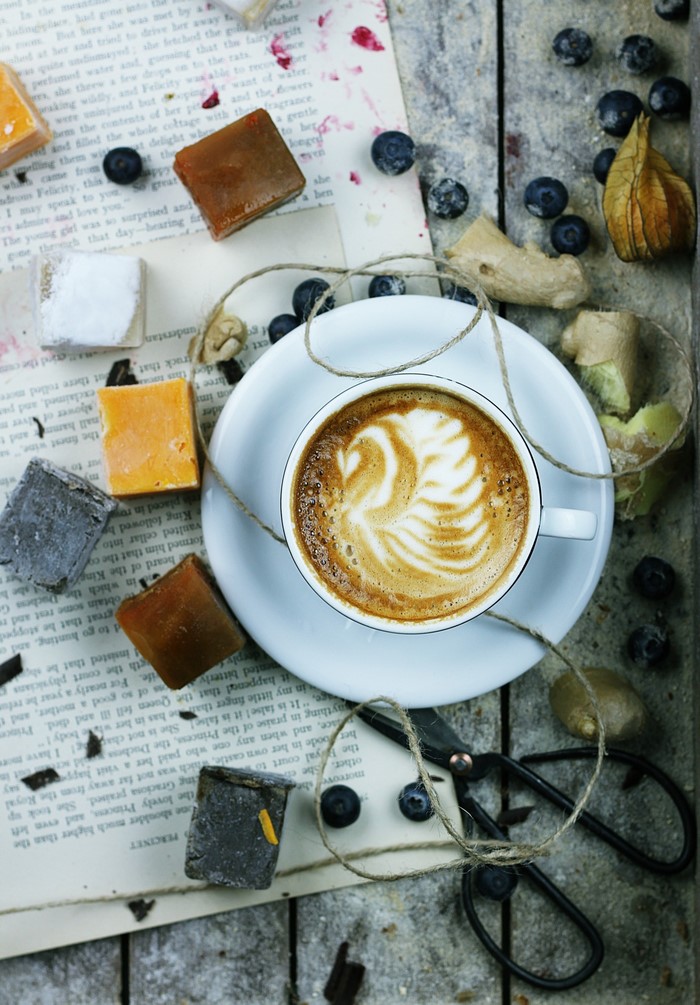 Cappuccino with latte art, cheese, blueberries, ginger, and scissors