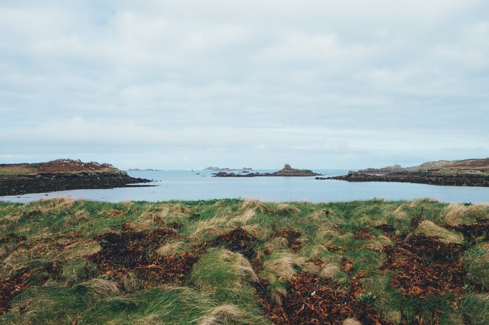 Rocky islands in a calm sea under a cloudy sky