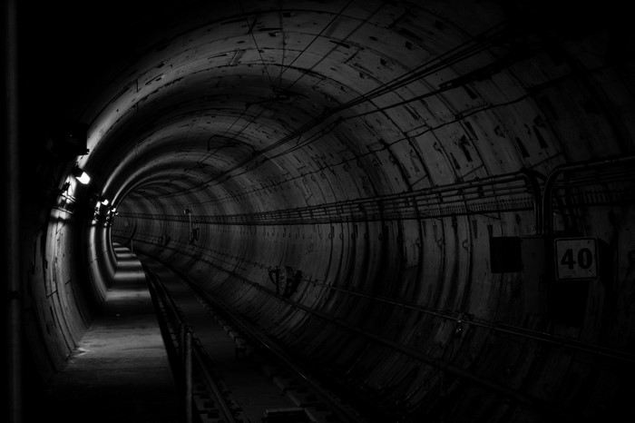 Monochrome photography of a subway tunnel with tracks