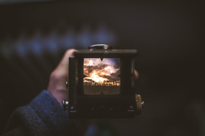 Vintage camera viewfinder showing sunset over trees