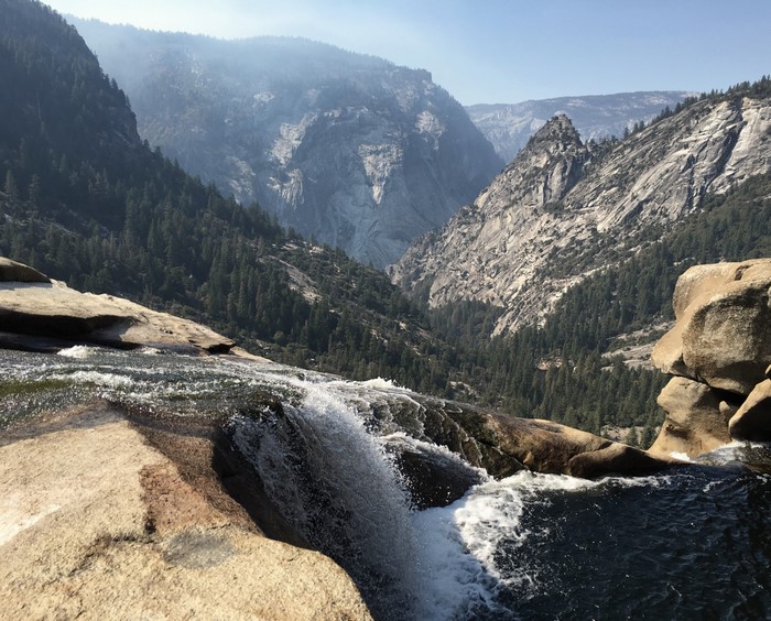 Waterfall overlooking a forested mountain valley