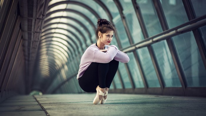 Woman in ballet attire posing in a glass tunnel