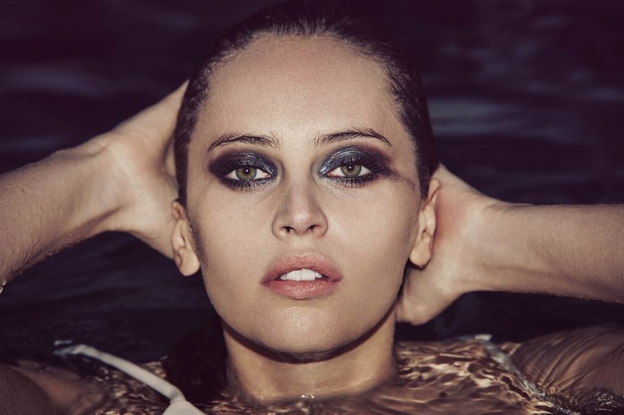 Felicity Jones in swimming pool with hands on head