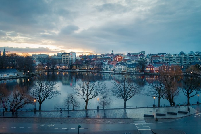 Cityscape with lake at sunset with reflections