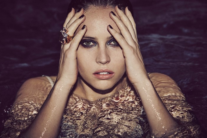 Felicity Jones in water with hands on head