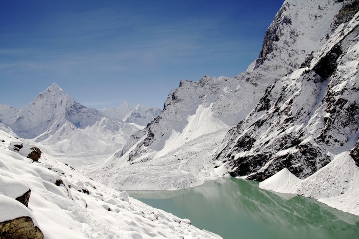 Snowy mountain range with a turquoise lake and glacier