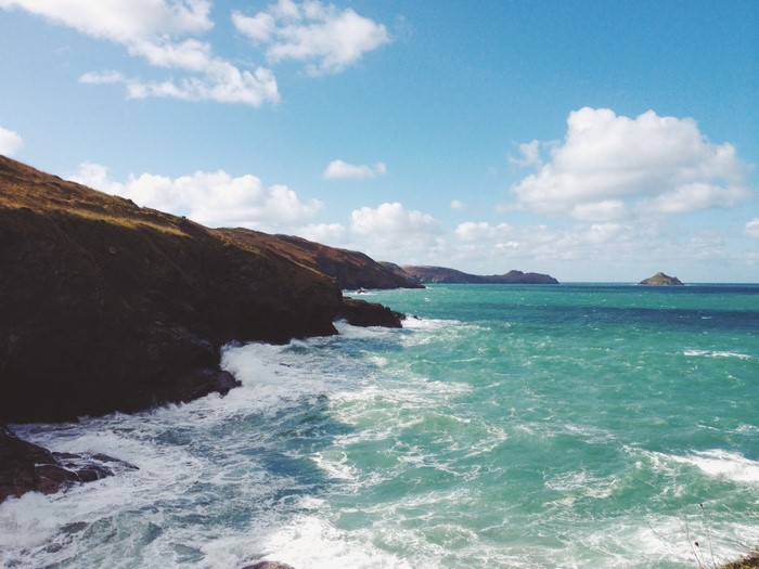 Rugged coastline with turquoise ocean waves crashing against cliffs