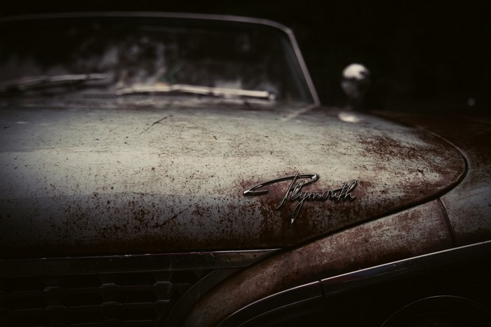 Close up of a rusty vintage Plymouth car hood
