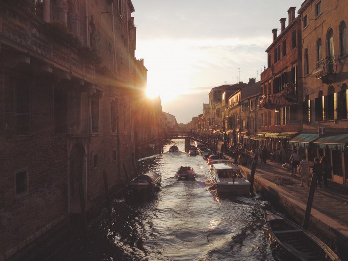 Venice canal at sunset with boats and buildings