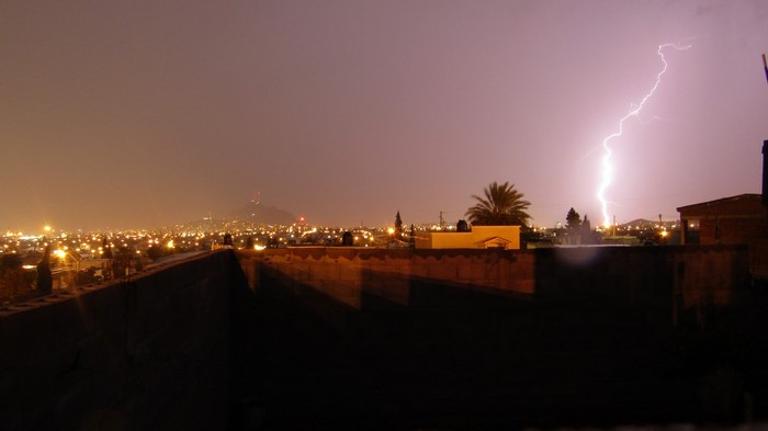 Lightning strikes over a city at night