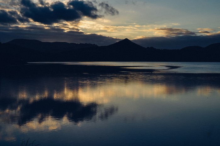 Silhouette of mountains and lake at sunset
